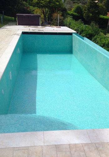 ​​Piscina a sfioro in cemento armato, rivestimento mosaico